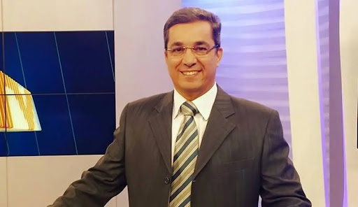 Ted Conti apresentando telejornal em estúdio de televisão
